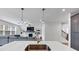 Bright living room with a fireplace, built-in shelves, a gray sofa, and pendant lights over the kitchen island at 1393 Halpern Nw Ln, Kennesaw, GA 30144