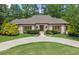 Elegant one-story home features a circular driveway, manicured lawn, and lush landscaping at 194 Sentinel Se Pl, Marietta, GA 30067