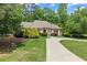 Beautifully landscaped front yard with lush green lawn, shrubs, and a curved driveway leading to the entrance at 194 Sentinel Se Pl, Marietta, GA 30067