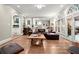 Bright living room with hardwood floors, a brown leather sofa, and arched windows overlooking the backyard at 194 Sentinel Se Pl, Marietta, GA 30067