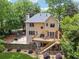 View of a two-story home's backyard with a wooden deck, basketball court, and surrounding trees and lush landscaping at 2622 Murdock Rd, Marietta, GA 30062