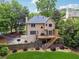 View of a two-story home's backyard with a wooden deck, basketball court, and surrounding trees and lush landscaping at 2622 Murdock Rd, Marietta, GA 30062