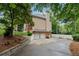 Side view of a two-story home with an attached two-car garage, brick foundation, driveway, and lush landscaping at 2622 Murdock Rd, Marietta, GA 30062