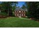 Elegant brick home featuring a well-manicured lawn, mature trees, and inviting entrance way at 2622 Murdock Rd, Marietta, GA 30062