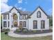 Stately two-story home featuring a white facade, black trim, arched windows, and a beautifully landscaped front yard at 4519 Mossey Dr, Lithonia, GA 30038