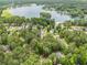 Aerial view showcasing homes nestled among lush trees near a serene lake at 5008 Monticello Dr, Villa Rica, GA 30180