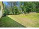 Spacious backyard featuring a lush green lawn, mature trees, and ample space for outdoor activities at 5008 Monticello Dr, Villa Rica, GA 30180