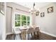 Bright dining area with modern chandelier, white table, and large window showcasing lush greenery at 5008 Monticello Dr, Villa Rica, GA 30180