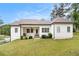 Rear exterior featuring a covered porch, stone steps, well-kept lawn, and modern farmhouse appeal at 5008 Monticello Dr, Villa Rica, GA 30180
