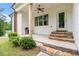 Covered porch showcasing stone steps, wood columns, grill, and neat landscaping, inviting relaxation at 5008 Monticello Dr, Villa Rica, GA 30180