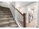 Carpeted staircase with wooden banister leads to a kitchen area with stainless steel appliances at 5008 Monticello Dr, Villa Rica, GA 30180