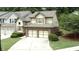 Aerial view of a two-story home featuring a two-car garage, brick accents, shuttered windows, and well-maintained lawn at 989 Brownstone Ln # 16, Marietta, GA 30008