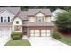 Aerial view of a two-story home featuring a two-car garage, brick accents, shuttered windows, and well-maintained lawn at 989 Brownstone Ln # 16, Marietta, GA 30008