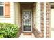Close-up of a welcoming front door with decorative wreath and brick accents and manicured bushes at 989 Brownstone Ln # 16, Marietta, GA 30008