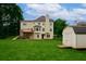 Expansive backyard with a shed and a two-story home featuring a deck, perfect for outdoor gatherings at 1847 Oak Rd, Snellville, GA 30078