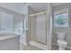 Well-lit bathroom featuring a bathtub, a shower with glass doors, and a toilet at 1847 Oak Rd, Snellville, GA 30078
