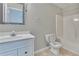 Well-lit bathroom featuring a white vanity, patterned mirror, and a toilet with a shower/tub combo at 1847 Oak Rd, Snellville, GA 30078