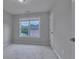 Cozy bedroom with neutral carpet, a double window, and a door at 1847 Oak Rd, Snellville, GA 30078