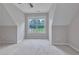 Spacious bedroom with neutral walls and carpet, lit by natural light through a large window at 1847 Oak Rd, Snellville, GA 30078