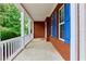 Inviting covered front porch with white columns and brick facade, a perfect spot to relax at 1847 Oak Rd, Snellville, GA 30078