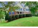 Landscaped front yard with green lawn, mature trees, and neatly trimmed hedges enhances curb appeal at 1847 Oak Rd, Snellville, GA 30078
