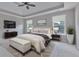 Staged main bedroom boasts a tray ceiling, sitting area, and ample natural light at 1847 Oak Rd, Snellville, GA 30078