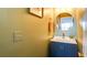 Stylish powder room featuring a blue vanity, round mirror, and modern fixtures, adding a touch of elegance at 2410 Clock Face Ct, Lawrenceville, GA 30043