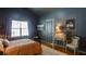 Comfortable bedroom with a warm color scheme, a desk, and a window that lets in natural light at 2410 Clock Face Ct, Lawrenceville, GA 30043