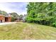 Lush, grassy backyard with mature trees and a glimpse of the brick house, offering a serene outdoor space at 2668 Kings Park Cir, Decatur, GA 30034