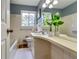 Bright bathroom featuring white tiled walls, a tub, vanity, and a large mirror reflecting plants and natural light at 2668 Kings Park Cir, Decatur, GA 30034