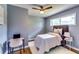 Cozy bedroom featuring a ceiling fan, a plush bed, and a dedicated workspace with desk and chair at 2668 Kings Park Cir, Decatur, GA 30034