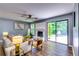 Bright living room featuring hardwood floors, a painted brick fireplace, and backyard access at 2668 Kings Park Cir, Decatur, GA 30034