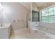 Bright bathroom featuring a soaking tub with tile surround and large window view at 307 Lee Miller Dr, Suwanee, GA 30024
