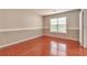Bright bedroom featuring gleaming hardwood floors and a large window at 307 Lee Miller Dr, Suwanee, GA 30024