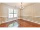 Elegant dining room with hardwood floors, wainscoting detail, and a large window, perfect for entertaining at 307 Lee Miller Dr, Suwanee, GA 30024