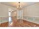 Spacious dining area with hardwood floors, wainscoting, and chandelier, adjacent to the living room at 307 Lee Miller Dr, Suwanee, GA 30024