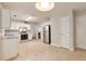 Bright, spacious kitchen with tile flooring, white cabinets, stainless steel appliances and views to the living room at 307 Lee Miller Dr, Suwanee, GA 30024
