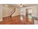 Open-concept living room features hardwood floors, a staircase, and views into the dining room and kitchen at 307 Lee Miller Dr, Suwanee, GA 30024