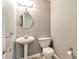 Cozy powder room features pedestal sink, round mirror, and updated fixtures at 307 Lee Miller Dr, Suwanee, GA 30024