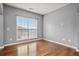 An empty bedroom with light gray walls, wood floors, and a bright window at 456 Crestmont Ln, Canton, GA 30114