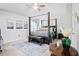 Bright bedroom featuring a four-poster bed, light gray walls, a ceiling fan, and unique decorative wall art at 456 Crestmont Ln, Canton, GA 30114
