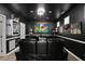 Modern home theater featuring tiered seating, a large screen, and movie-themed decor against a black backdrop at 456 Crestmont Ln, Canton, GA 30114