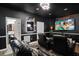 Home theater room with black walls, tiered seating, a large screen, and movie-themed decor at 456 Crestmont Ln, Canton, GA 30114