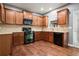 A functional kitchen featuring wood cabinets, tile backsplash, and black appliances at 456 Crestmont Ln, Canton, GA 30114