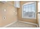 Well-lit laundry room featuring tile floors, a utility sink, and a window with natural light at 456 Crestmont Ln, Canton, GA 30114