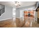 Living room featuring hardwood floors, stone fireplace, staircase, and access to the kitchen for easy entertaining at 456 Crestmont Ln, Canton, GA 30114