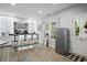 Bright wet bar area with barstool seating, illuminated display shelving, and stainless steel refrigerator at 456 Crestmont Ln, Canton, GA 30114