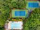 Overhead view of a community pool and tennis courts bordered with lush, tall trees and greenery at 710 Devon Hill Ct, Roswell, GA 30075