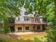 Rear view of a two-story house with a wooden deck and patio that offer great outdoor entertaining at 710 Devon Hill Ct, Roswell, GA 30075