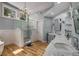 Bright bathroom featuring double sinks, natural wood floors, and a glass shower at 710 Devon Hill Ct, Roswell, GA 30075